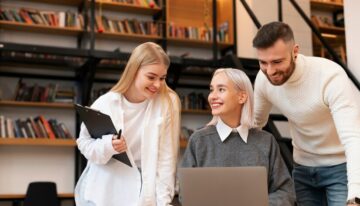 colleagues-studying-library-reading-from-laptop_23-2149283321
