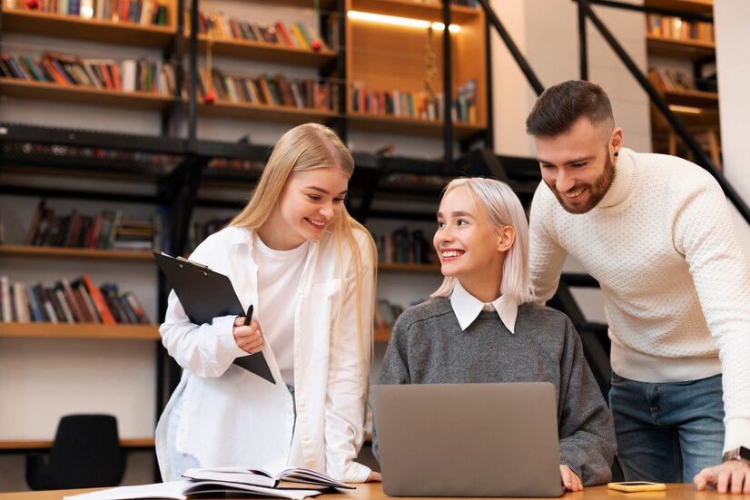 colleagues-studying-library-reading-from-laptop_23-2149283321
